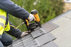 Roofer installs shingles on a new residential roof