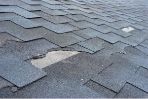 Torn shingles on old roof