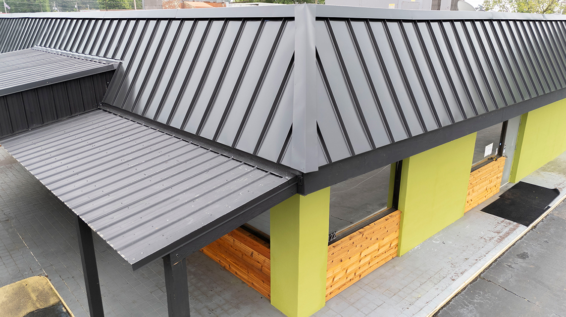 Commercial building with a sleek gray metal roof, showcasing a modern and durable roofing system.